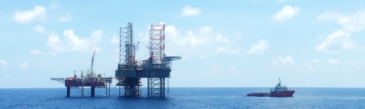 Oil and gas platform with offshore vessel transporting cargo