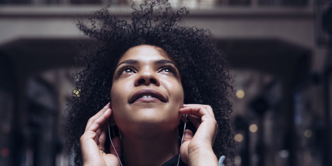 topical programming, African American women listens to music with headphones