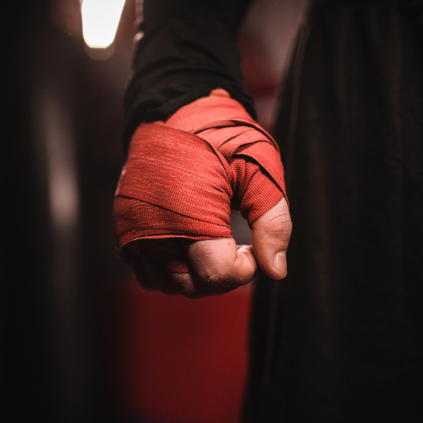 One man, kickboxer with wrapped boxing bandages on hand.
