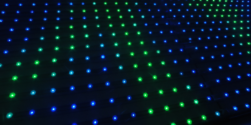 a wall of blue and green pin lights