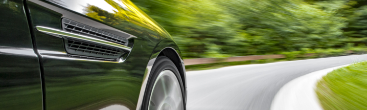 Motion blur shot of a sports coupe driving fast in a curve