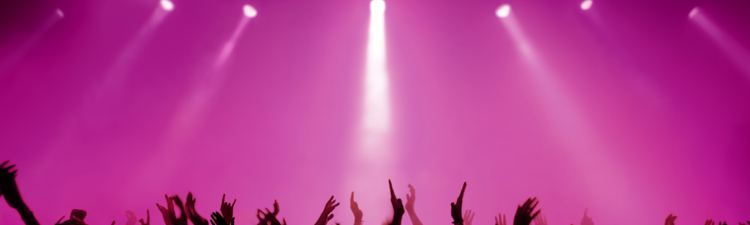 silhouettes of people on a rock concert raising hands