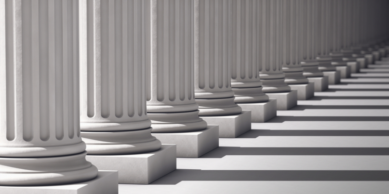 A row of columns diminishes to the vanishing point and out of focus.Computer Generated for perfect shadow angles and crisp columns.