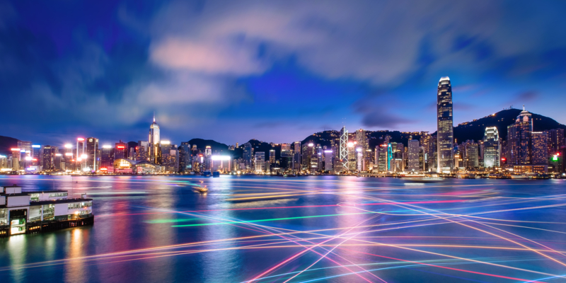 The world famous night scene of Hong Kong city skyline with star ferry navigates across Victoria Harbour
