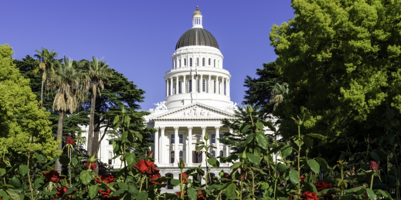 California State Capitol Building with red roses in the foreground in Sacramento, CA, USA