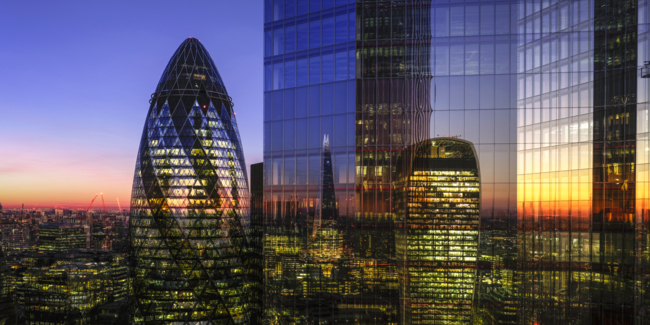 UK, London, digital composite of modern skyscrapers in the financial district viewed from high up, illuminated at dusk