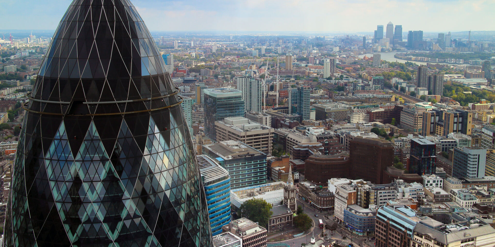 London panoramic view over Gherkin, Canary Wharf and the Thames river, taken on a cloudy, summer day